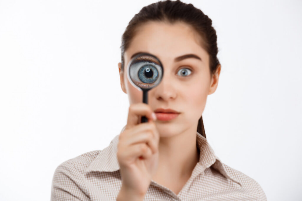 An eye patient for iSurgeon, looking through a magnifying glass depicting common eye conditions