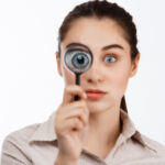 An eye patient for iSurgeon, looking through a magnifying glass depicting common eye conditions